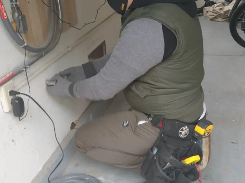 Electrician performing outlet wiring in a Winchendon garage